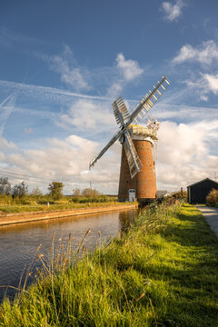 Horsey Windpump beside Norfolk Broads waterway beneath a dramatic autumn sky