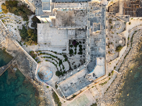 Aerial view of abandoned Jerma hotel and rocky Malta shoreline in daylight