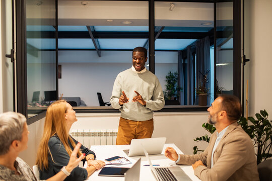 Team leader presenting to colleagues in modern office