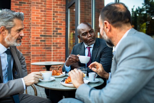 Business executives meeting over coffee at outdoor cafe