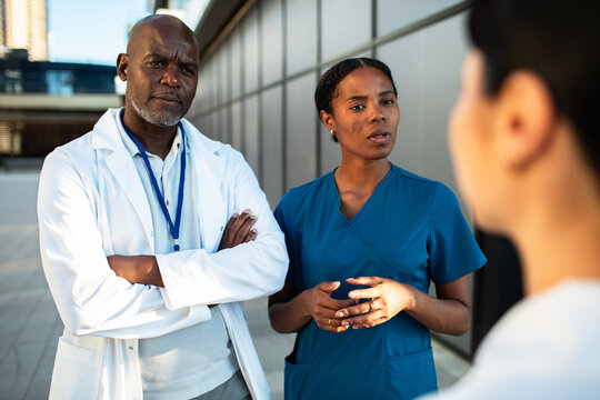 Medical team discussing patient case outside hospital