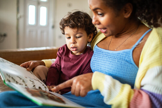 Parent and child reading picture book at home