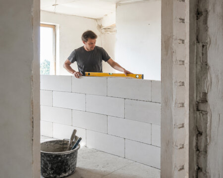 Trabajador construyendo una pared de bloques en un edificio en construcci&oacute;n