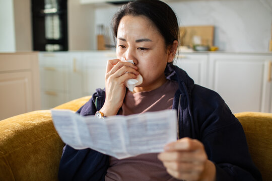 Sick woman reading medication instructions at home