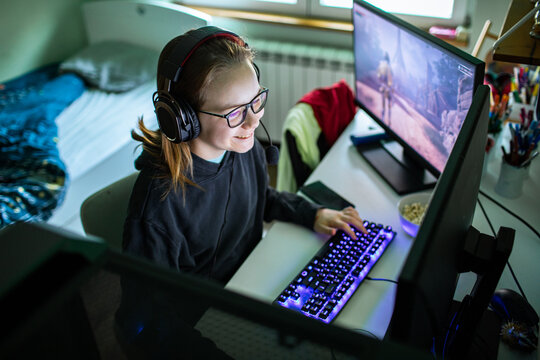 Teen gamer using pc at home desk