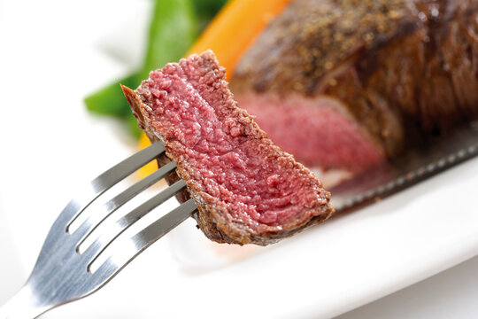 Piece of beef filet on fork, elevated view