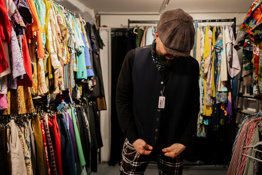 Man tries on a vest at a vintage clothing market