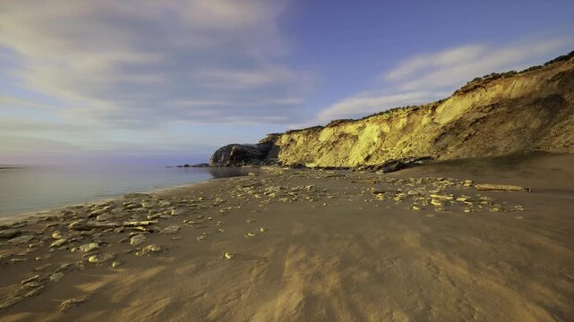elevated drone view of Paracas coastline revealing sweeping cliffs, narrow beaches, scattered boulders and layered textures with clean horizon and expansive sea