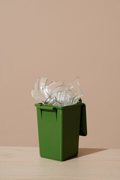 Glass fragments in green recycling bin representing waste separation