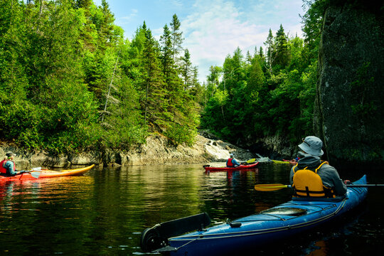 Sea kayakers explore rocky river waterfall channel