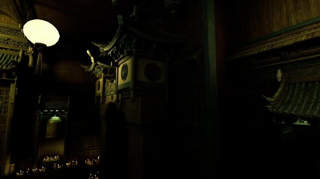 Gilded temple interior moody lowlight with ornate altars, carved pillars, hanging lanterns, warm gold highlights, deep shadows, incense haze, quiet ceremonial