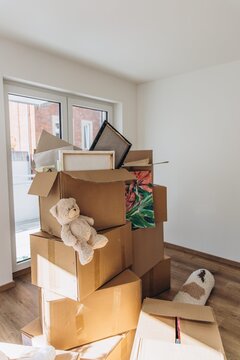 Stacked moving boxes and household items in an empty room during relocation