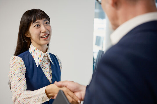 Businesswoman shakes hands with a businessman during an interview