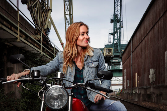Portrait of smiling young woman on motorcycle