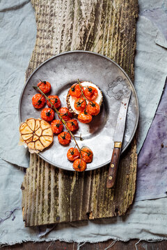 Roasted tomatoes, crostini with goat cheese, garlic on plate