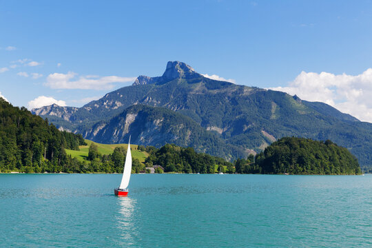 Austria, Upper Austria, Salzkammergut, View of sailing boat in Mondsee Lake, Schafberg in the background