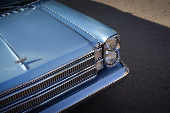 Details of front of light blue Ford Galaxie 500 Convertible (1966) showing hood emblem, chrome grille and stacked headlights. Subotica, Serbia - July 4, 2026.