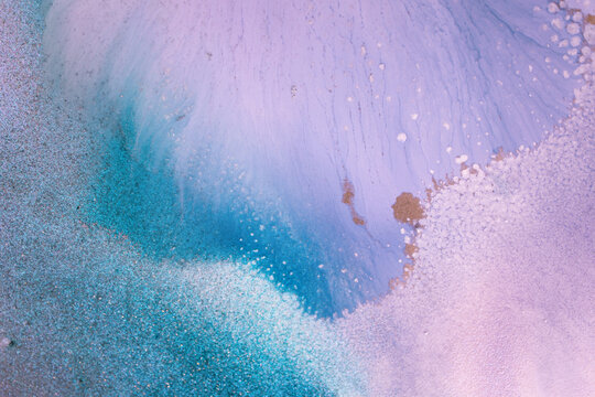 The picture is painted in alcohol ink. Creative abstract artwork made with translucent ink colors. Trendy wallpaper. Abstract painting, can be used as a background for wallpapers, posters, websites.