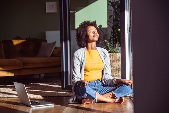 Woman enjoys warm sunlight during a work break in her home office