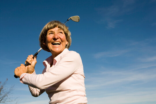 Senior adult woman holding golf club