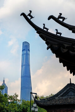 A dramatic contrast between Shanghai Tower and ornate temple rooflines against a cloudy sky, Shanghai, China 31 July 2026