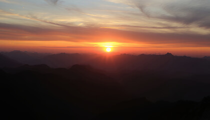 Fototapeta premium Fiery Sunset Over Silhouetted Mountain Landscape