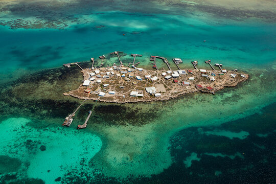 Aerial view of Pigeon Island in the Houtman Abrolhos archipelago, featuring small buildings, jetties, and turquoise waters in Houtman Abrolhos, Western Australia, Australia.
