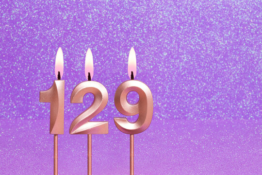 Number 129 on a pink background with blurred bright dots