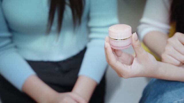 Beauty bloggers influencers live streaming skincare tutorial with closeup cream moisturizer application and product review, gentle focus, calm guidance, cozy home scene on sofa, chat, demo, glow