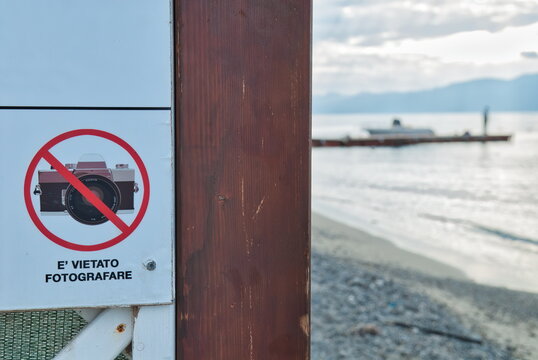 Cartello con divieto di fotografare sulla spiaggia con mare sullo sfondo