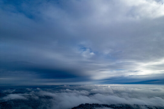 Aerial view of the clouds covering the landscape around Mummelsee in Seebach, Baden-Wurttemberg, Germany.
