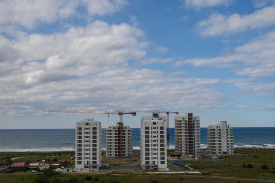 Construction of modern buildings by the seaside under a dynamic cloud-filled sky