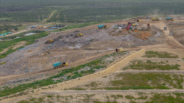 Aerial view of Vissershok Road landfill site with heavy machinery and trucks operating on piles of waste in Cape Town, Western Cape, South Africa.
