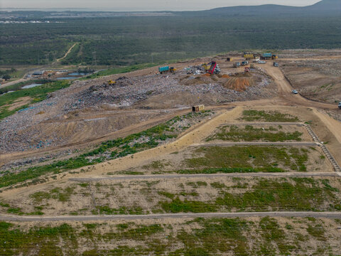 Aerial view of the Vissershok Road landfill site with heavy machinery and trucks working on waste management operations in Cape Town, Western Cape, South Africa.