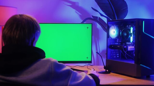 Computer with chroma key green screen on monitor. Gamer man playing in popular video games. Programmer or hacker coding a code and working in networks, cyberspace. Digital software, mobile app