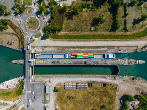 Aerial view of a cargo ship navigating through the lock at Vogelgrun, Grand Est, France.