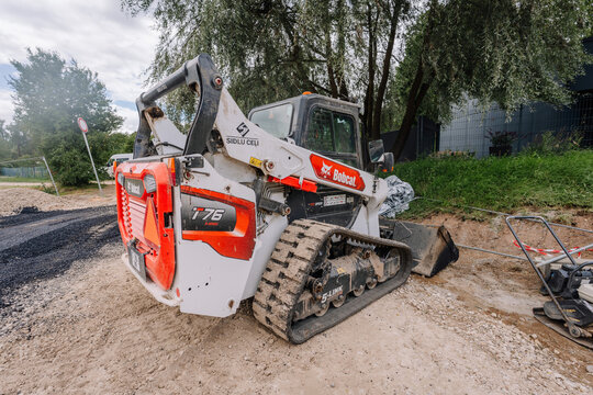 Bobcat E76 compact excavator parked on a construction site with gravel and machinery visible in the background