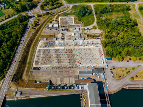 Aerial view of the electrical substation and hydroelectric power facility located near the river in Vogelgrun, Grand Est, France.