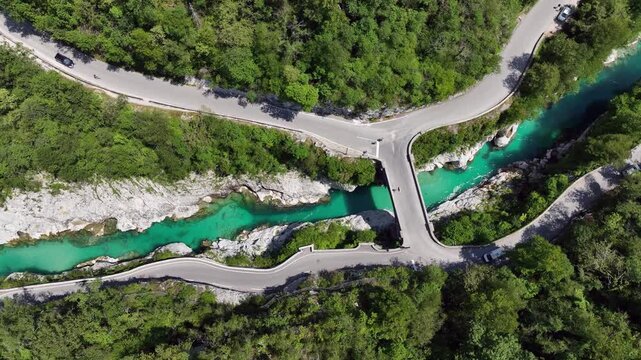 Aerial top down perspective captures turquoise Soca river crystal clear water. rocky canyon banks surrounded by dense wild green forest near Kobarid.