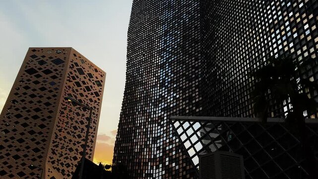 Low Angle Pan Of Modern Skyscrapers Silhouette Against Dramatic Golden Hour Sunset