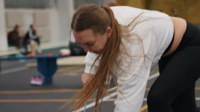 White woman tuning badminton shuttlecock precision, closeup of toss and grip, methodical serve and spin practice, climbing wall gym background, concentrated facial focus, stepwise technique