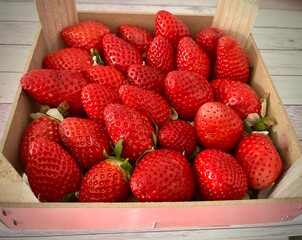 Fresas rojas y frescas recolectadas dentro de una caja de madera rústica de madera listas para su consumo © GILPEDRO