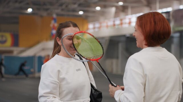 Participants share joyful celebratory gestures. Teams exchange greetings within friendly setting. Participants engage in mutual appreciation through smiles amidst festive and supportive atmosphere