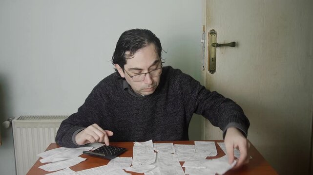 Frustrated Caucasian Man Feeling Overwhelmed by Piles of Receipts and Expenses