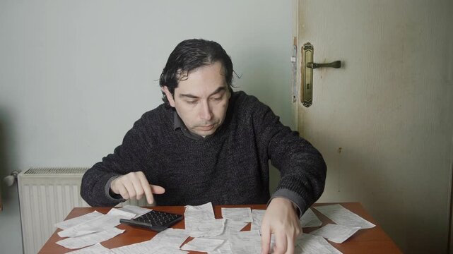Adult Man Auditing Financial Papers and Managing Home Budget at Desk