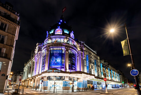 Paris, France - December 24, 2025: Exterior view of Le BHV Marais department store decorated with holiday lights at night.