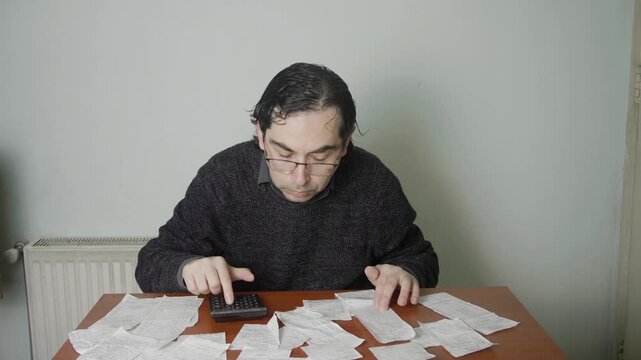 Mid Shot of Exhausted Man Taking Off Glasses and Leaning Back While Auditing Receipts