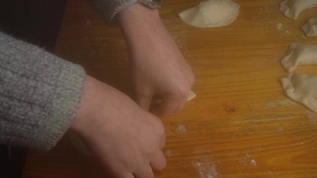 High Angle Shot of Hands Pleating and Folding Homemade Empanada Dough