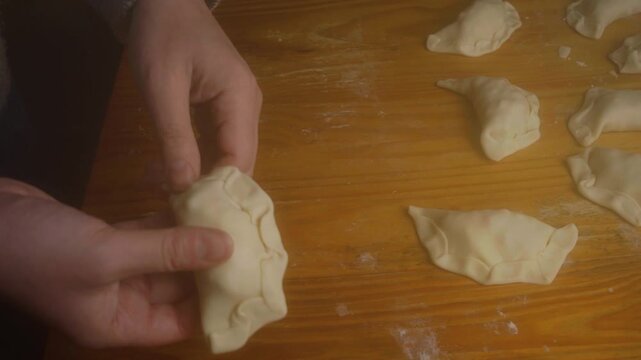 High Angle Shot of Hands Putting Finishing Touches on Homemade Empanada Pastry