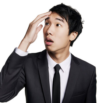 Young man in a suit looking surprised with hand on forehead